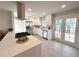 Bright kitchen featuring stainless appliances, white cabinetry, and a convenient center island with cooktop at 1853 S Filbert Ct, Denver, CO 80222