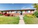 Charming single story home with well-maintained lawn, beautiful landscaping, and solar panels on the roof at 41 S Fenton St, Lakewood, CO 80226