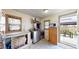 Bright laundry room with washer and dryer, stained glass style windows and access to the backyard at 41 S Fenton St, Lakewood, CO 80226