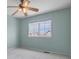 Cozy bedroom with a large window, ceiling fan, and neutral carpeting at 23525 Painted Hills St, Parker, CO 80138