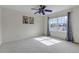 Bright bedroom featuring a ceiling fan, a large window with curtains, and neutral carpet at 23525 Painted Hills St, Parker, CO 80138