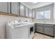 Well-equipped laundry room featuring a washer, dryer, sink, window, and storage cabinets at 23525 Painted Hills St, Parker, CO 80138