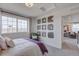 Bright bedroom featuring a large window, modern art, and a peek into the bonus room at 1212 Sugarloaf Ln, Erie, CO 80516