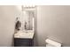 This is a bathroom featuring a sink, mirror, and toilet, with neutral paint and textured walls at 5177 Delphinium Cir, Brighton, CO 80601