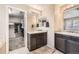 This bathroom has an ensuite closet, double vanity sink, and tile flooring at 5177 Delphinium Cir, Brighton, CO 80601