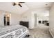 This bedroom has neutral walls, a ceiling fan, an ensuite bathroom, and a fireplace at 5177 Delphinium Cir, Brighton, CO 80601