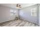 This bedroom features two windows, wood-look flooring, and neutral-painted walls at 5177 Delphinium Cir, Brighton, CO 80601