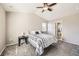 A bedroom with neutral walls, a ceiling fan, a bed, and a bathroom doorway at 5177 Delphinium Cir, Brighton, CO 80601