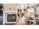 Open dining room and kitchen with a fireplace, hardwood floors, and natural light at 5177 Delphinium Cir, Brighton, CO 80601