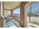 Charming front porch has bistro set and brick columns and a view of the street at 5177 Delphinium Cir, Brighton, CO 80601