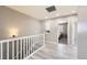 A well-lit second story hallway features a staircase and artwork with access to multiple rooms at 5177 Delphinium Cir, Brighton, CO 80601