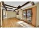 Living room features wood floors, wooden beams, and large double doors to the outside at 778 Suncrest Rd, Palmer Lake, CO 80133