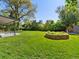 Well-maintained backyard featuring a covered patio, a grass lawn, mature trees, and landscaping at 3560 S Glencoe St, Denver, CO 80237