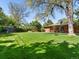 Spacious backyard with mature tree, shed, and brick home offers a private and serene outdoor setting at 3560 S Glencoe St, Denver, CO 80237