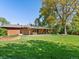Expansive lawn with lush greenery and a brick home provides ample outdoor space for recreation and relaxation at 3560 S Glencoe St, Denver, CO 80237