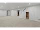 Spacious basement featuring neutral carpet, white walls, and stairs leading to the upper level at 3560 S Glencoe St, Denver, CO 80237