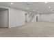 Spacious basement featuring neutral carpet, white walls, and stairs leading to the upper level at 3560 S Glencoe St, Denver, CO 80237