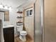 Bathroom featuring a shower, toilet, vanity, shelves, and window at 3560 S Glencoe St, Denver, CO 80237