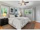 Cozy bedroom with large bed, area rug, two windows, modern ceiling fan, and two lamps at 3560 S Glencoe St, Denver, CO 80237