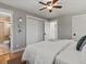 Bright bedroom with hardwood floors, a ceiling fan, closet and an open bathroom at 3560 S Glencoe St, Denver, CO 80237