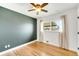 Neutral bedroom with a large window, hardwood floors, and modern ceiling fan at 3560 S Glencoe St, Denver, CO 80237