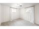 Bedroom featuring neutral carpet, two windows, and white paneled walls at 3560 S Glencoe St, Denver, CO 80237