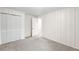 Bedroom featuring neutral carpet, built-in closet and access to other rooms at 3560 S Glencoe St, Denver, CO 80237
