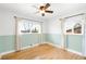 Cozy bedroom with hardwood floors, bright windows, and modern ceiling fan at 3560 S Glencoe St, Denver, CO 80237