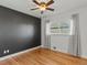 Hardwood bedroom has gray wall, ceiling fan, white trim and a large window with curtains at 3560 S Glencoe St, Denver, CO 80237