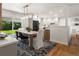 Open concept dining area with modern light fixture, with an area rug and sliding doors leading to a spacious backyard at 3560 S Glencoe St, Denver, CO 80237