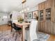 Open dining room with a modern light fixture, decorative wall art and a built-in wooden cabinet at 3560 S Glencoe St, Denver, CO 80237