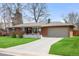 Inviting brick home with a lush green lawn and a spacious driveway leading to an attached garage at 3560 S Glencoe St, Denver, CO 80237