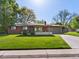 Charming brick ranch home with a well-manicured lawn and a long driveway leading to an attached garage at 3560 S Glencoe St, Denver, CO 80237