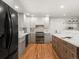 Modern kitchen with stainless steel appliances, white cabinets, and a wooden kitchen island at 3560 S Glencoe St, Denver, CO 80237