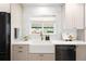 Bright kitchen featuring a farmhouse sink, stainless steel appliances, and ample counter space for cooking at 3560 S Glencoe St, Denver, CO 80237