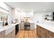 Modern kitchen with white cabinets, stainless steel appliances, a farmhouse sink, and an island with wood accents at 3560 S Glencoe St, Denver, CO 80237
