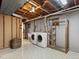 Basement laundry room featuring a washer, dryer, sink, wood shelves, and overhead lighting at 3560 S Glencoe St, Denver, CO 80237