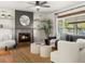 Cozy living room with a brick fireplace, neutral walls, and a ceiling fan that complement the natural light from the large window at 3560 S Glencoe St, Denver, CO 80237