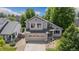Aerial view of a two-story home with mature trees, a well-manicured lawn, and a two car garage at 6230 Snowberry Ave, Firestone, CO 80504