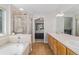 Bathroom featuring dual sinks, soaking tub, shower, and tiled flooring at 6230 Snowberry Ave, Firestone, CO 80504