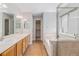 Bathroom features dual sinks, soaking tub, and a separate glass-enclosed shower at 6230 Snowberry Ave, Firestone, CO 80504