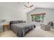 Serene bedroom with neutral tones, a ceiling fan, and a large window at 6230 Snowberry Ave, Firestone, CO 80504