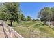 Picturesque green space with a white fence, mature trees, and a walking path, promoting an active lifestyle at 6230 Snowberry Ave, Firestone, CO 80504