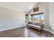 Cozy living room featuring wood floors, a gray sofa, and large windows at 6230 Snowberry Ave, Firestone, CO 80504