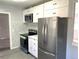 Updated kitchen with stainless appliances, white cabinets, and stylish backsplash at 1299 S Brentwood Way, Lakewood, CO 80232
