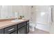 Bathroom with dark vanity, white fixtures and plenty of light at 18180 W 84Th Pl, Arvada, CO 80007