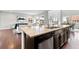 Kitchen with an island and seating overlooks the living and dining spaces in an open floorplan at 18180 W 84Th Pl, Arvada, CO 80007