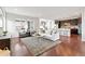 Open-concept living room with hardwood floors, a modern kitchen, and a comfortable seating area at 18180 W 84Th Pl, Arvada, CO 80007