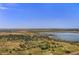 Scenic aerial view of a lake surrounded by lush landscapes and open fields under a clear blue sky at 13762 E Lehigh Ave # G, Aurora, CO 80014
