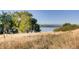 Picturesque lake view through trees and golden grass, offering a tranquil and scenic landscape at 13762 E Lehigh Ave # G, Aurora, CO 80014